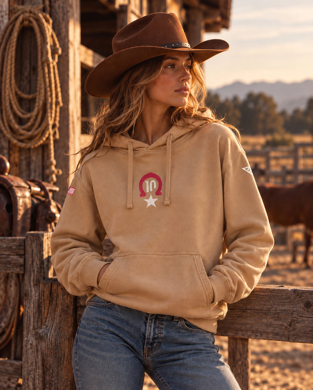 Woman in a cowboy hat wearing the sand Pierre Gasly Austin Hoodie, front view