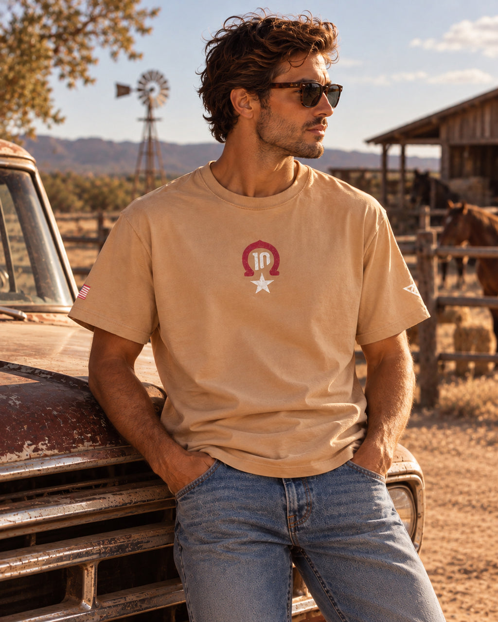 Man wearing the sand Pierre Gasly Austin Tee next to a vintage pickup truck, front view